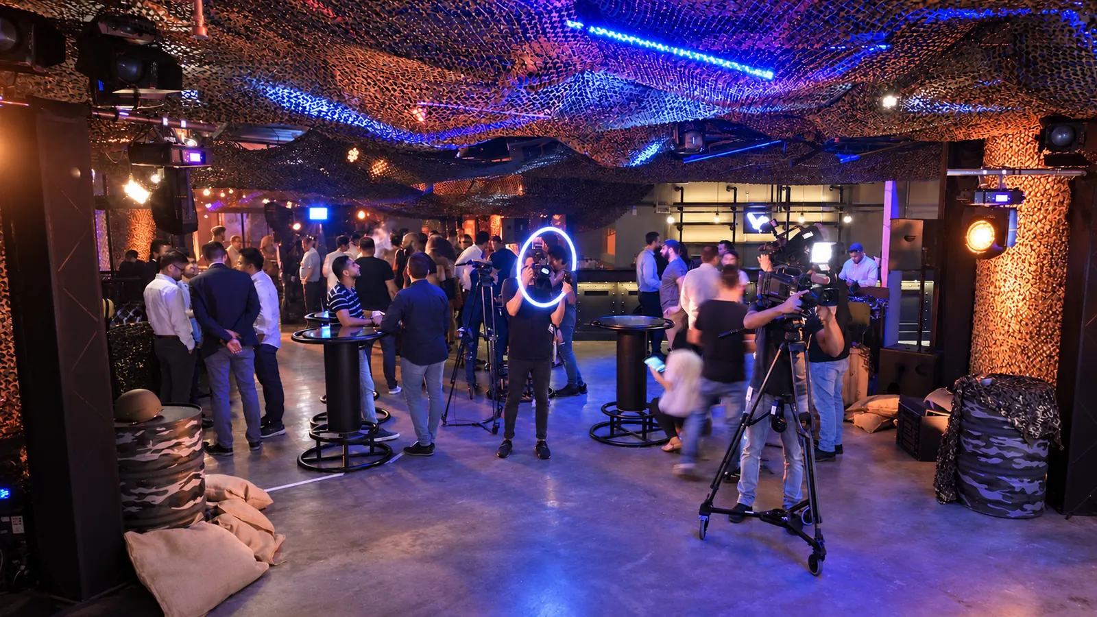 Guests and camera crews inside the camouflage-netted Invasion launch venue