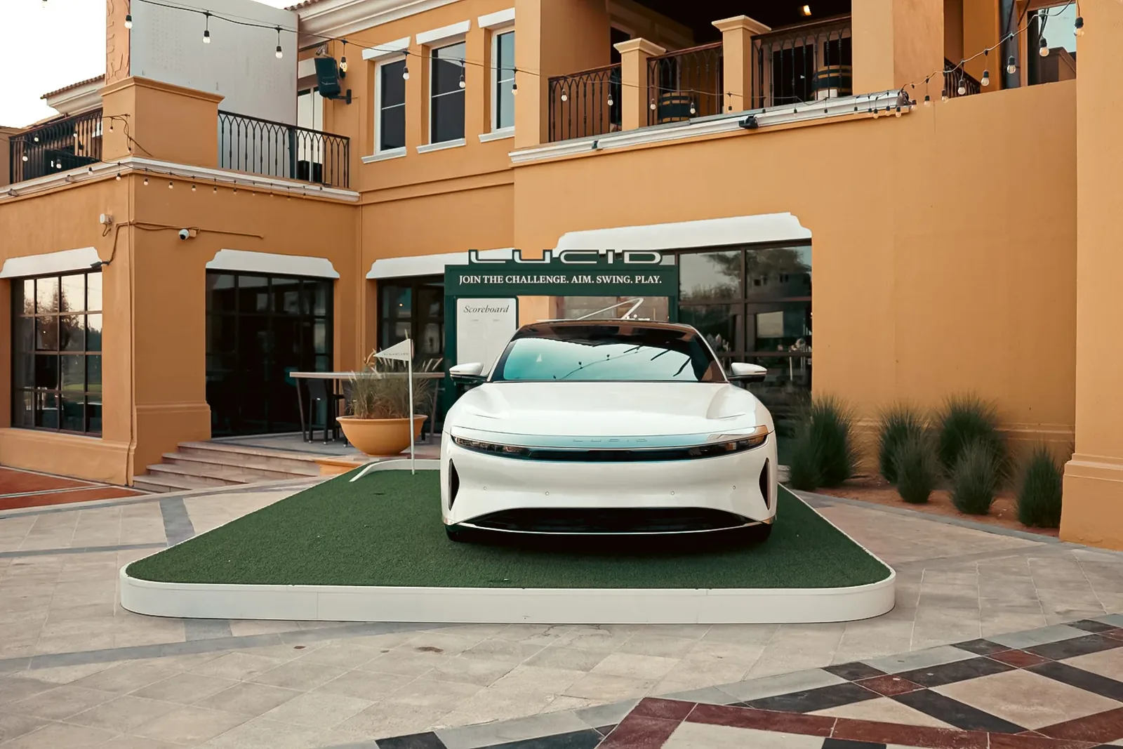 White Lucid Air on an artificial green in front of the clubhouse