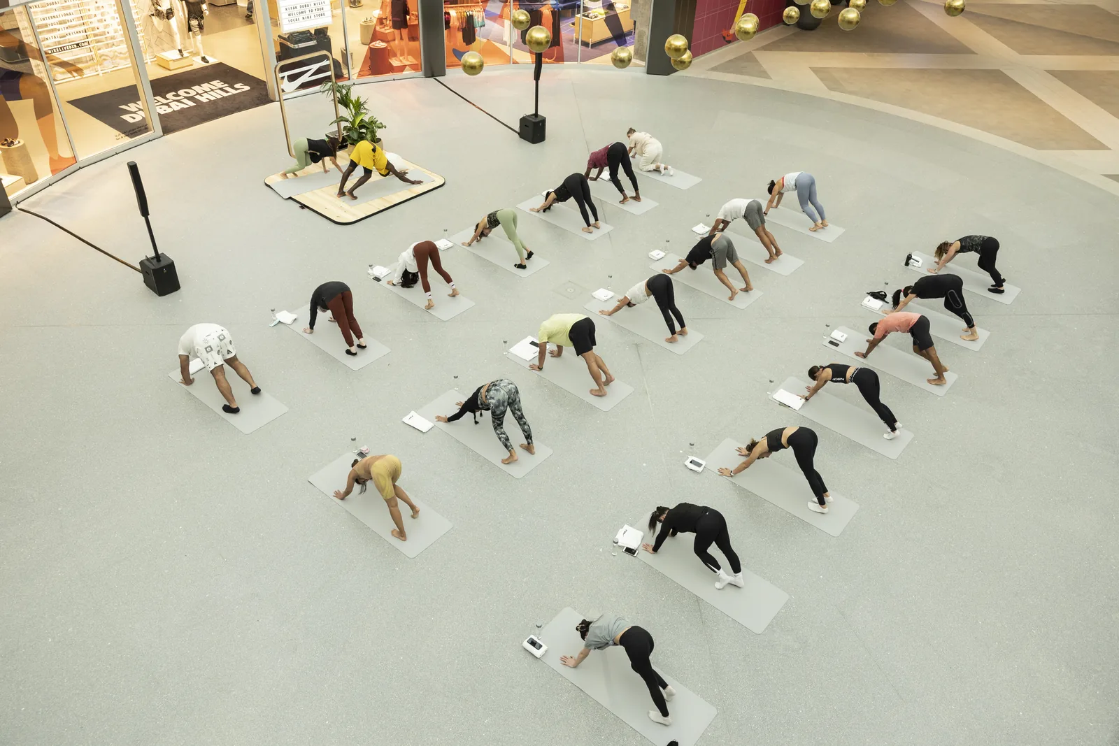 Aerial view of the class holding downward dog on white mats