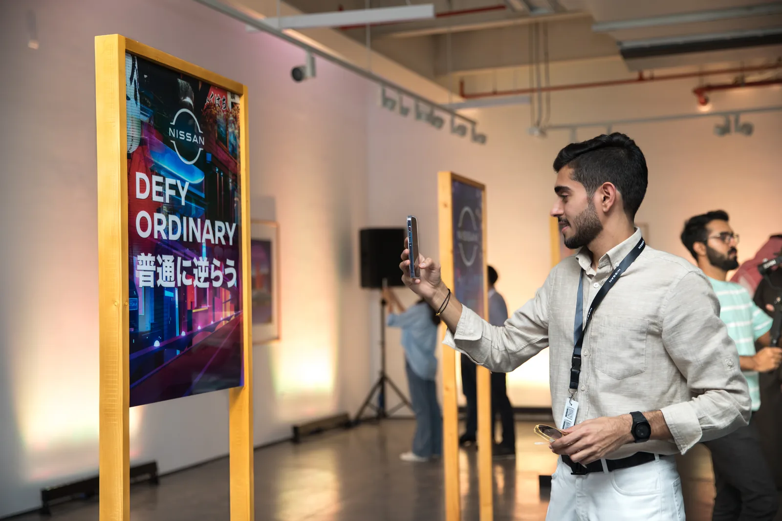 Guest pointing his phone at a Defy Ordinary poster to trigger the AR