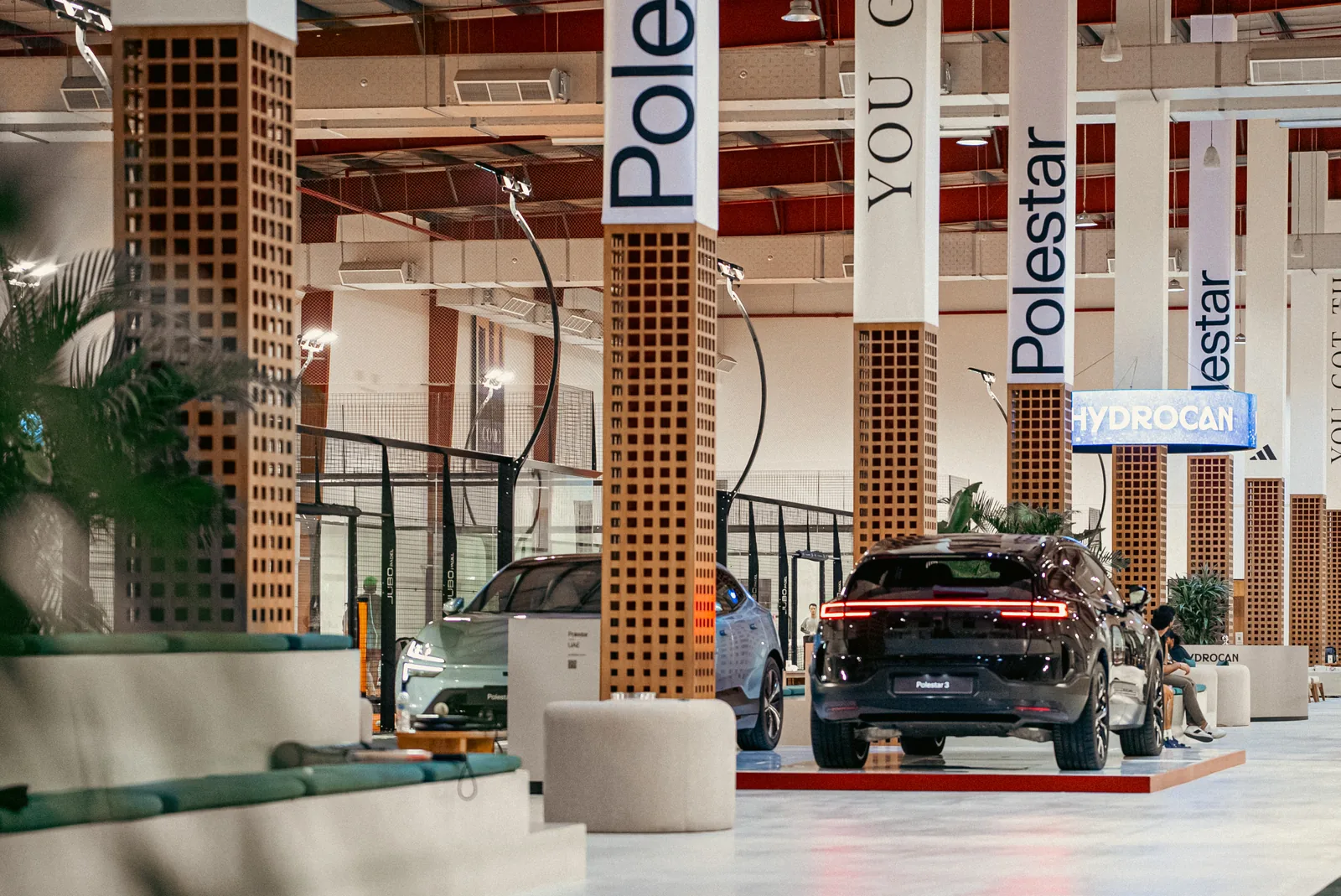 Polestar 3 and 4 among brick pillars in the padel club