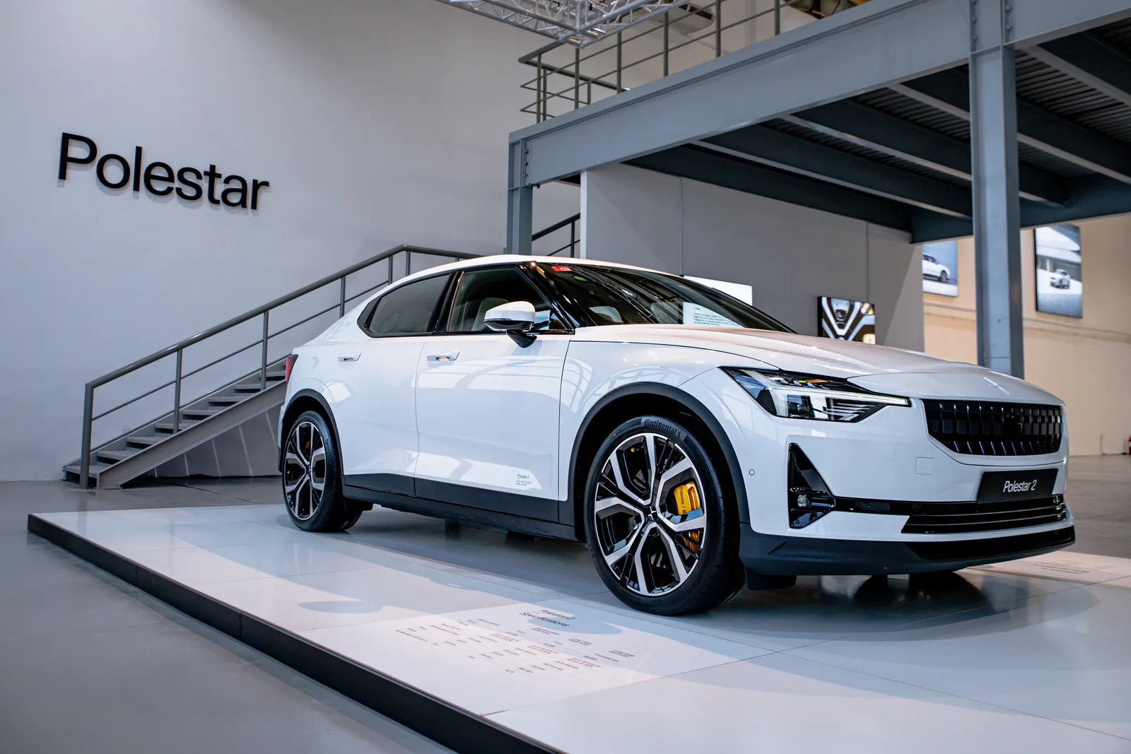 White Polestar 2 on a raised stage beside the staircase